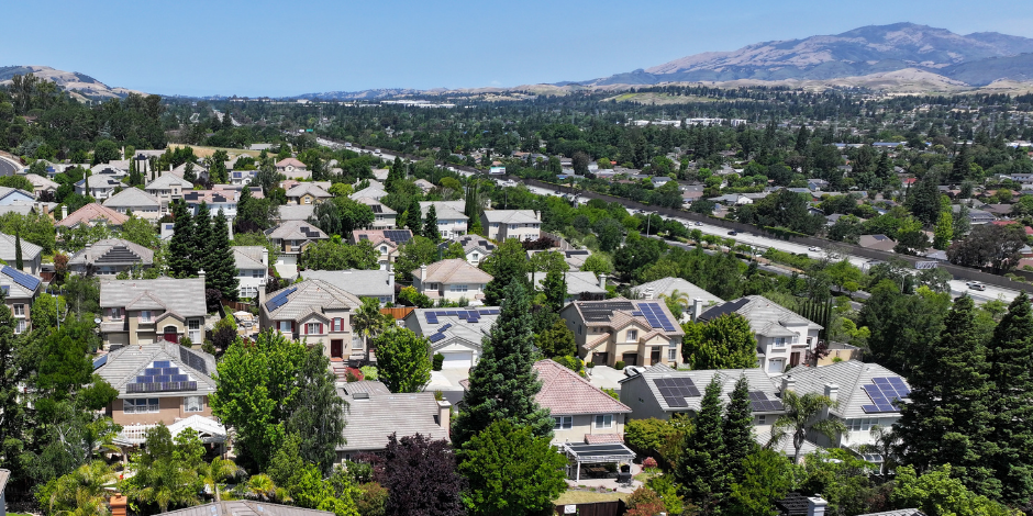 Drone view of Danville, CA rooftops with solar panels and the diablo range in the background